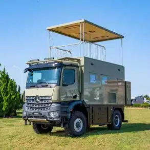 Mercedes Arocs K5 Flybridge Luxury Reisemobil mit ausgefahrener Flybridge auf einer Wiese