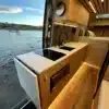 Küchenzeile und Innenraum eines luxuriös ausgebauten Mercedes Sprinter Campervans mit Naturholz und modernen Geräten