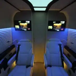 Innenraum eines Mercedes VIP Van von Delta Automotive mit LED-Ambientelicht, Ledersitzen und Bildschirmen.