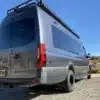 MLB Dreamer Campervan Sprinter 3500 extralang mit Allrad, fotografiert von hinten in einer Landschaft