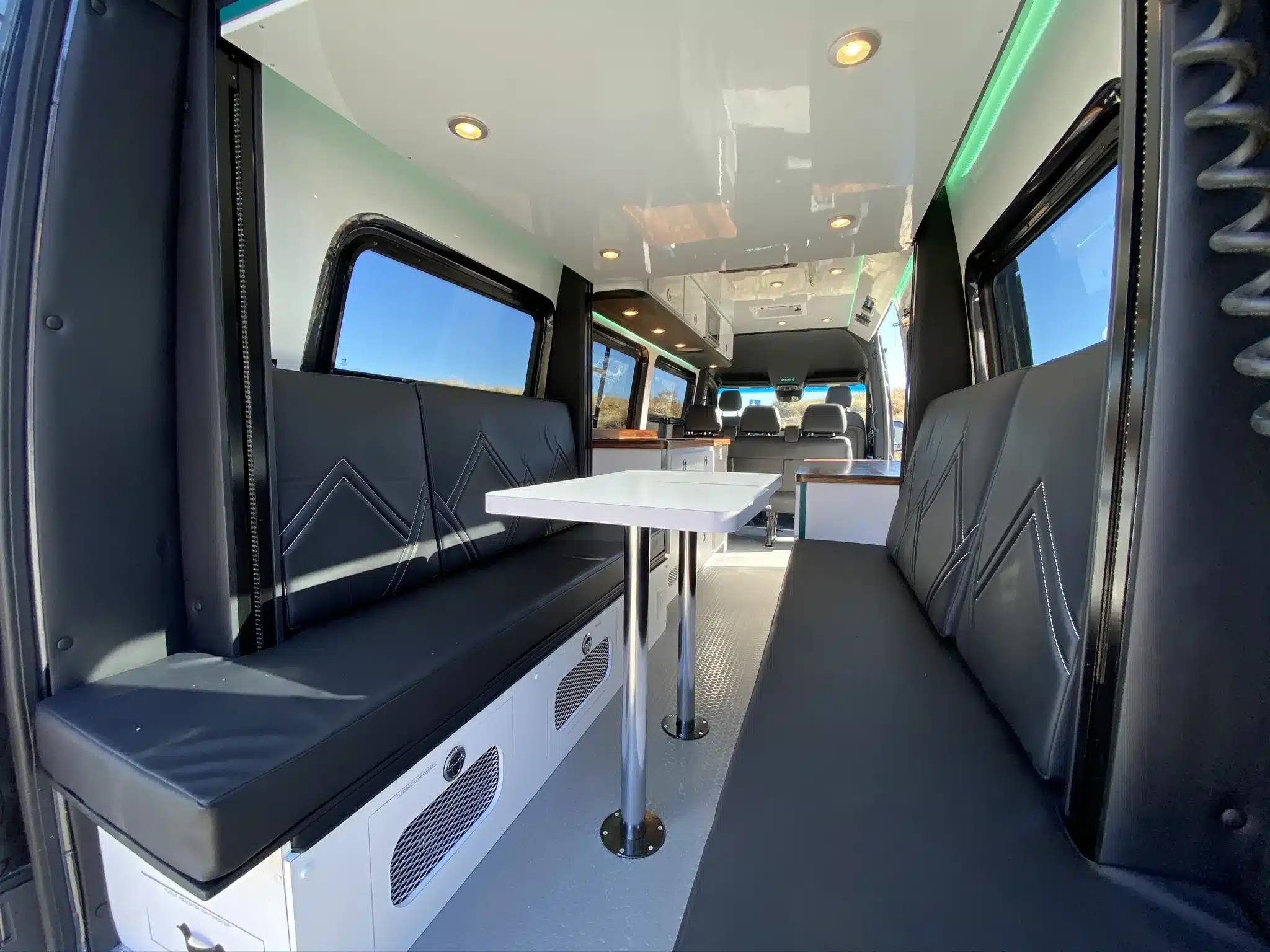 Innenansicht des MLB Dreamer Campervans mit Sitzbänken, Tisch und Blick auf die Ausstattung