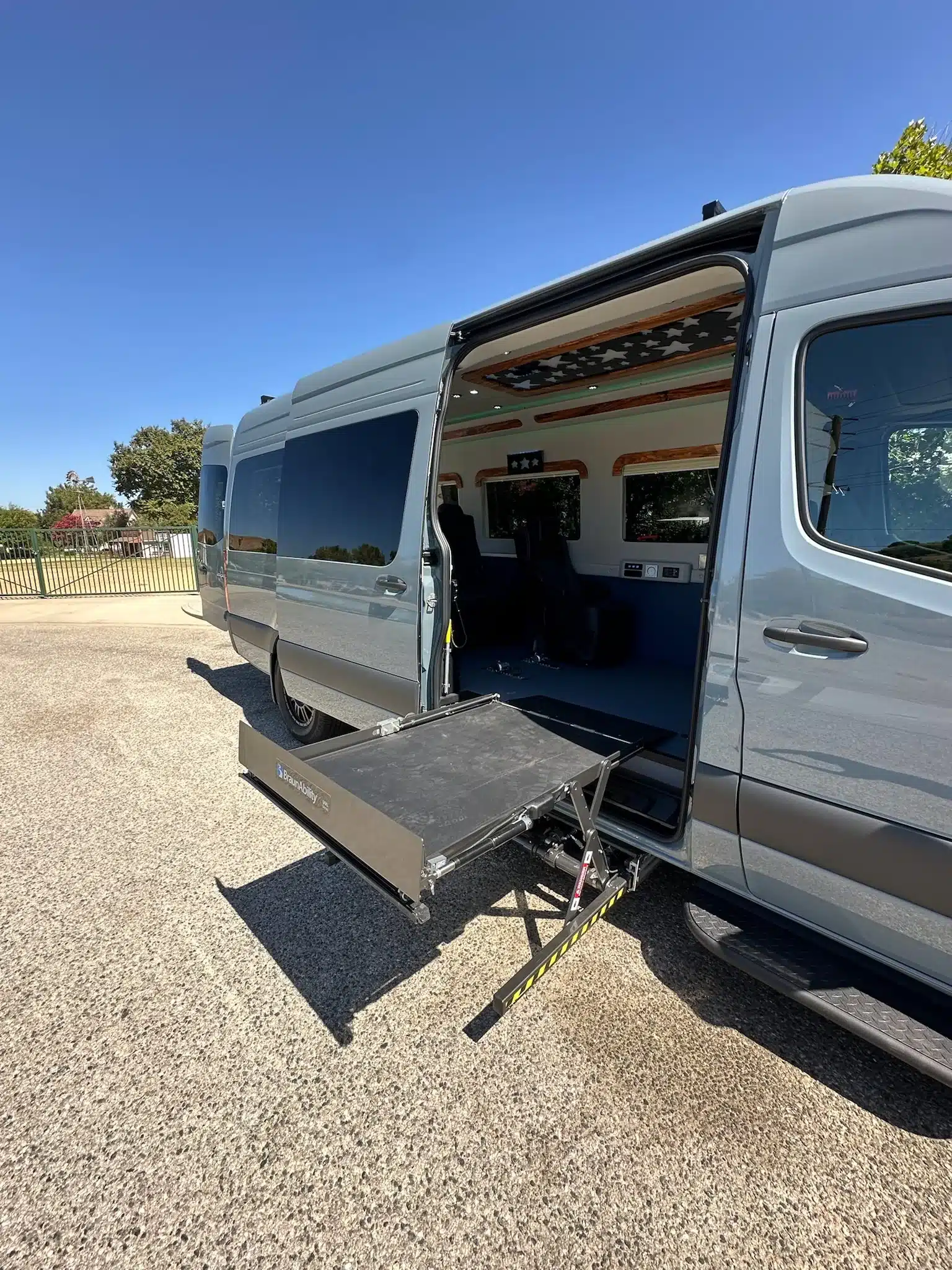 Mobility Van Ability Star mit ausgefahrenem seitlichen Unterflur-Lift an der geöffneten Schiebetür, bereit zur Rollstuhlaufnahme.
