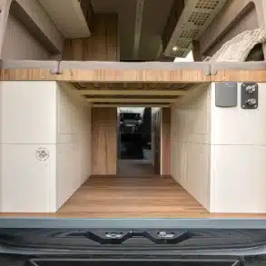 Blick von hinten in die geöffnete Heckgarage eines MAN oder VW Crafter mit eingebautem Moon Garage 4x4 ElectricThermo Modul, Stauraum und Schlafplattform