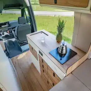 Küchenmodul Moon Kitchen Solid Model 1 UK eingebaut in einen Campervan mit Induktionskochfeld, Wasseranschluss und mehreren Schubladen.