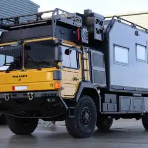 Der Motorcraft Juggernaut, ein massives Expeditionsfahrzeug mit Allradantrieb und hoher Bodenfreiheit, steht auf einem Werksgelände.