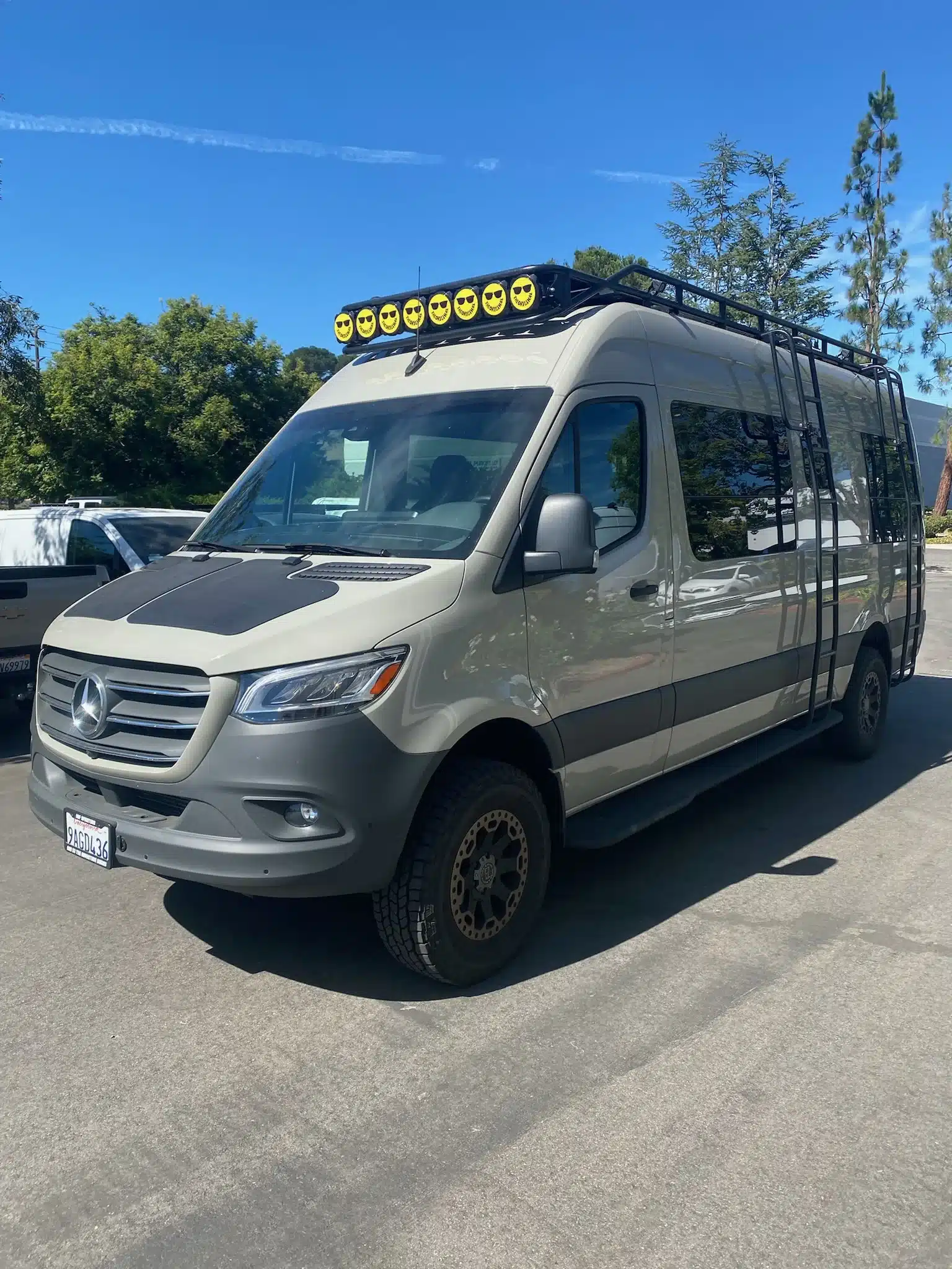 Frontansicht des Mercedes Sprinter 170 4x4 Campervans Nala mit Dachträger und Offroad-Bereifung auf einem Parkplatz.