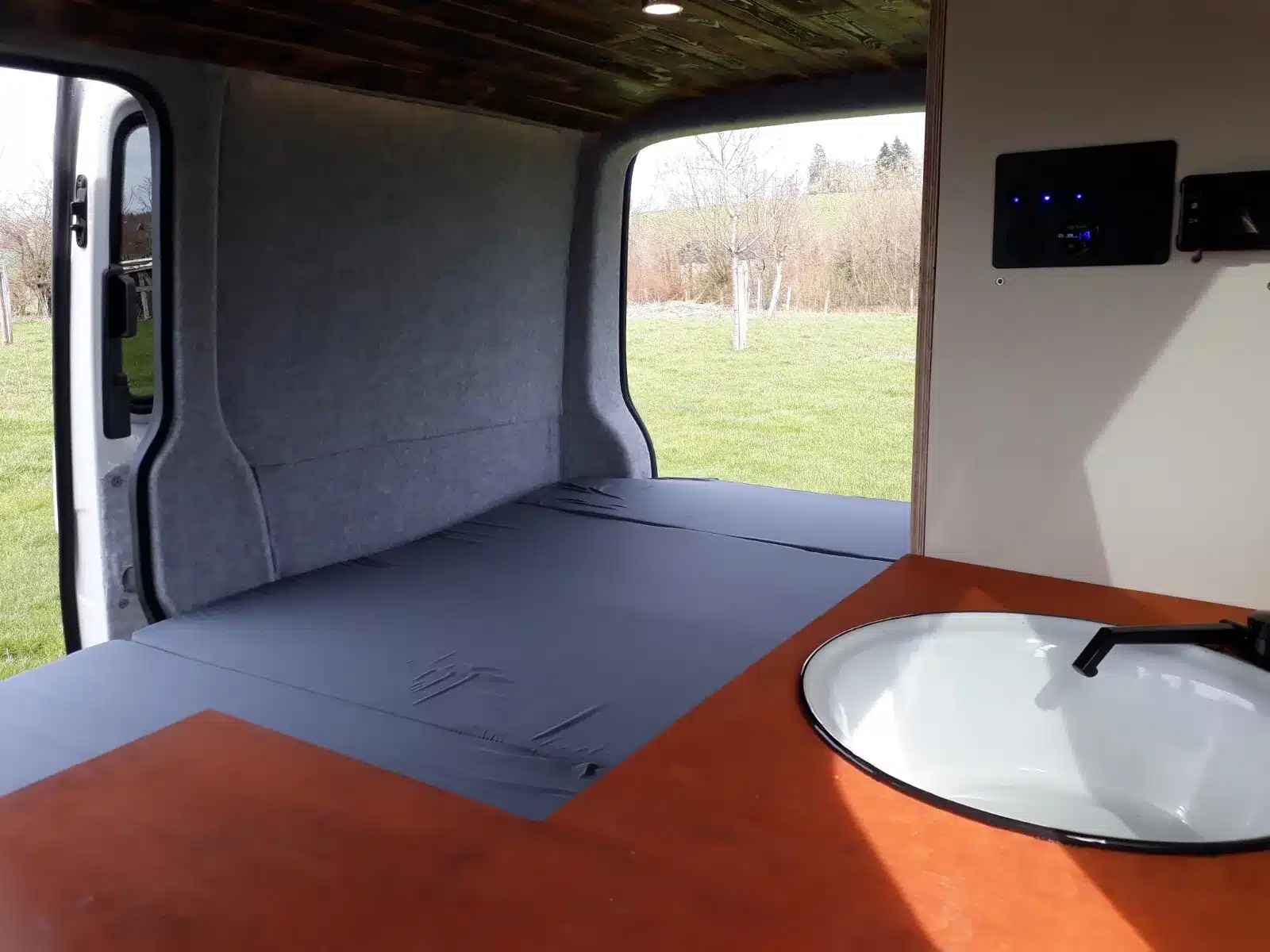 Flexibler Innenausbau im VW T5 Transporter mit ausgeklapptem Bett und Spüle
