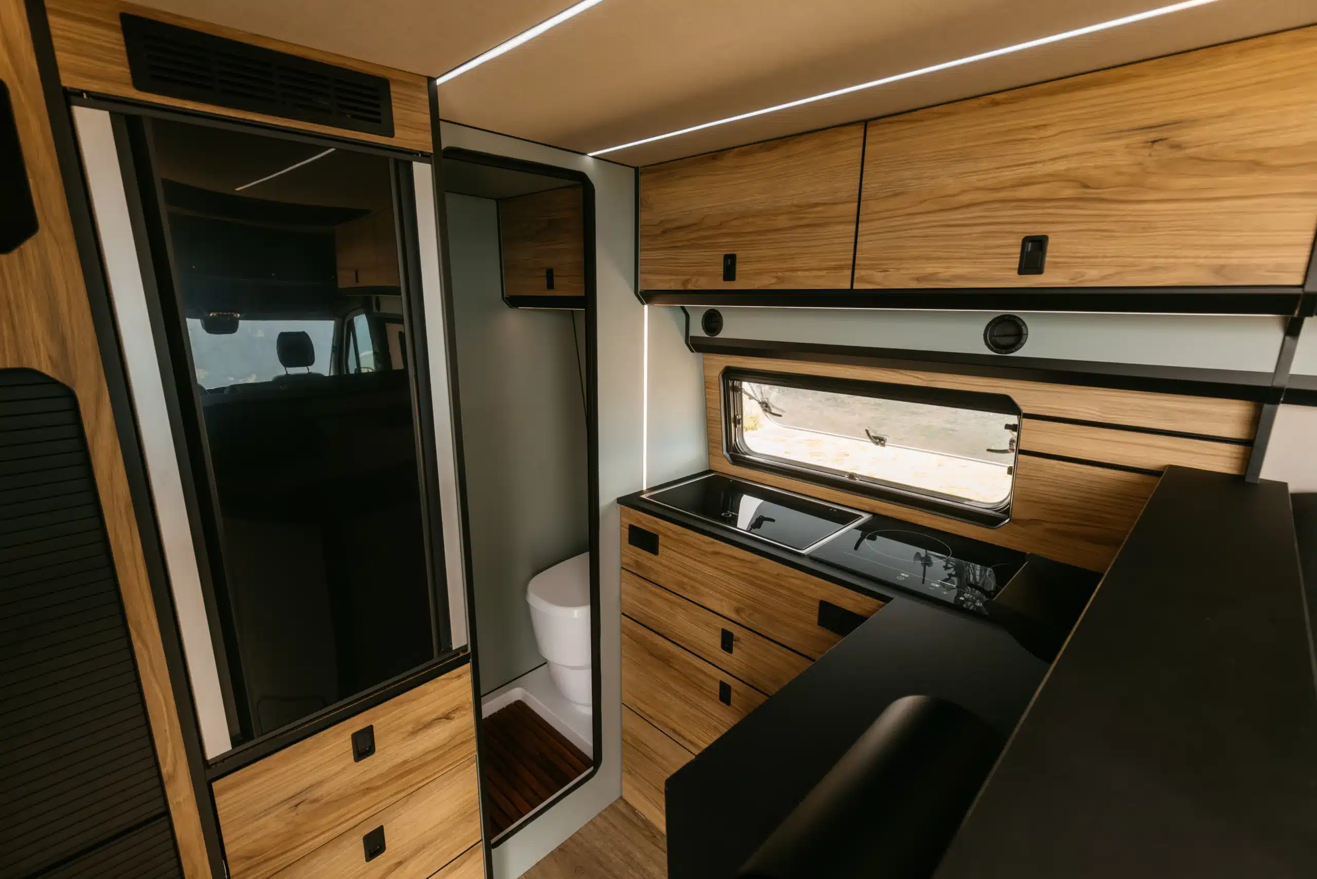 Innenansicht des NORANTZ EKI Camper Vans mit L-förmiger Küche, viel Stauraum und nachhaltigem Interieur