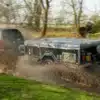 Off-Road Air OPUS Faltcaravan an einem Zugfahrzeug, fährt durch eine nasse Schlammpfütze im Gelände