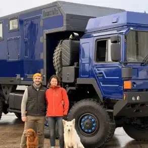 Blauer One Life Truck It Expeditions-Lkw mit Personen und Hunden auf Werkshof