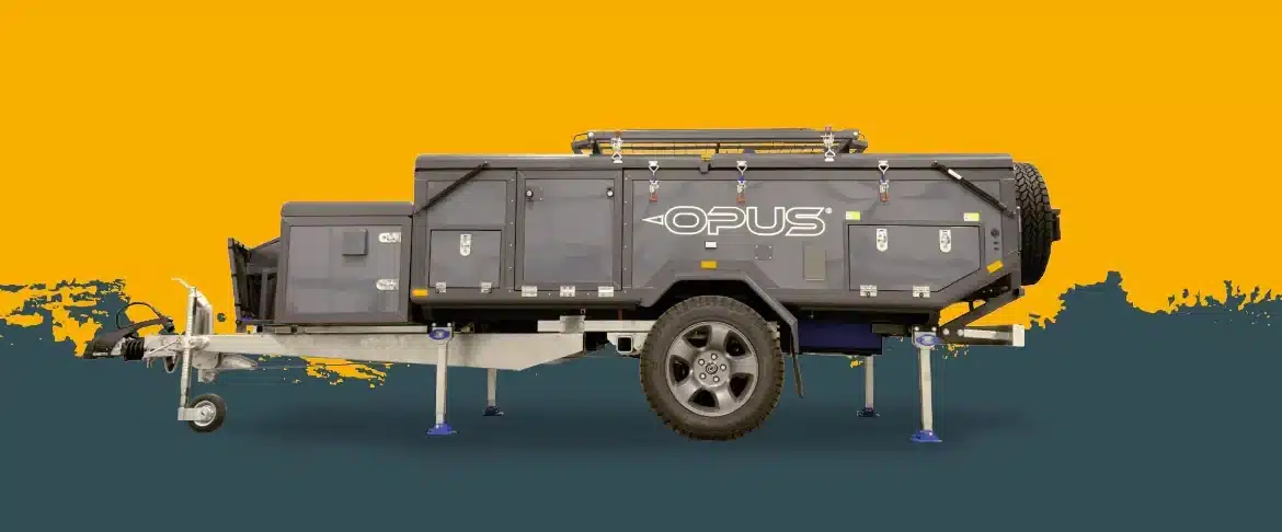 Seitenansicht des OPUS ORX Offroad-Faltcaravans mit stabilen Stützen und All-Terrain-Bereifung vor gelb-grauem Hintergrund.