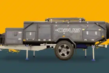 Seitenansicht des OPUS ORX Offroad-Faltcaravans mit stabilen Stützen und All-Terrain-Bereifung vor gelb-grauem Hintergrund.