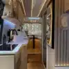 Moderner, heller Innenraum eines Camper Vans mit Küche, Sitz- und Schlafbereich im Japandi-Stil.