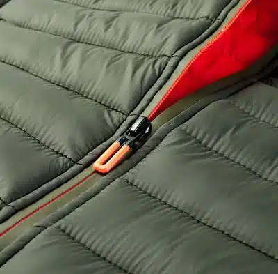 Detailfoto einer gesteppte PAXSON Outdoor Weste mit Reißverschluss in Dunkelgrün und Innenfutter in Orange