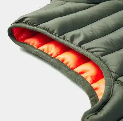 Detailaufnahme einer grünen, wattierten Outdoor-Weste mit orangem Innenfutter von PAXSON