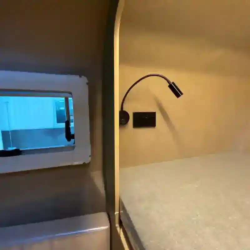 Schlafbereich mit Leselampe und Fenster im Pickup Truck Camper