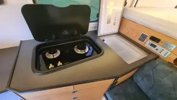 Küchenbereich mit Gasherd und Spüle in einer modernen Pickup-Wohnkabine