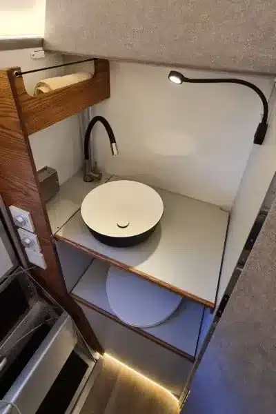 Waschbereich mit rundem Waschbecken und flexiblem Wasserhahn in einer Pickup-Wohnkabine.