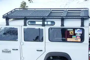 Qualan M Dachgepäckträger montiert auf einem weißen Land Rover Defender im Schnee