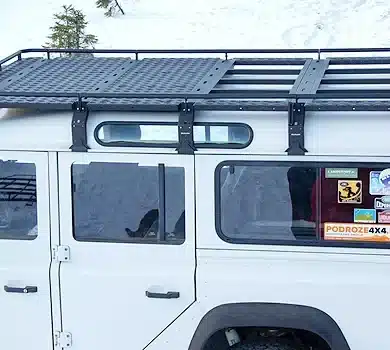 Qualan M Dachgepäckträger montiert auf einem weißen Land Rover Defender im Schnee