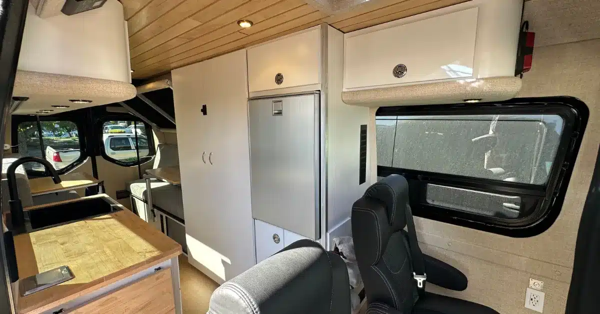 Innenraum eines ausgebauten Raven Adventure Vans mit moderner Küche, Sitzplätzen und Stauraum