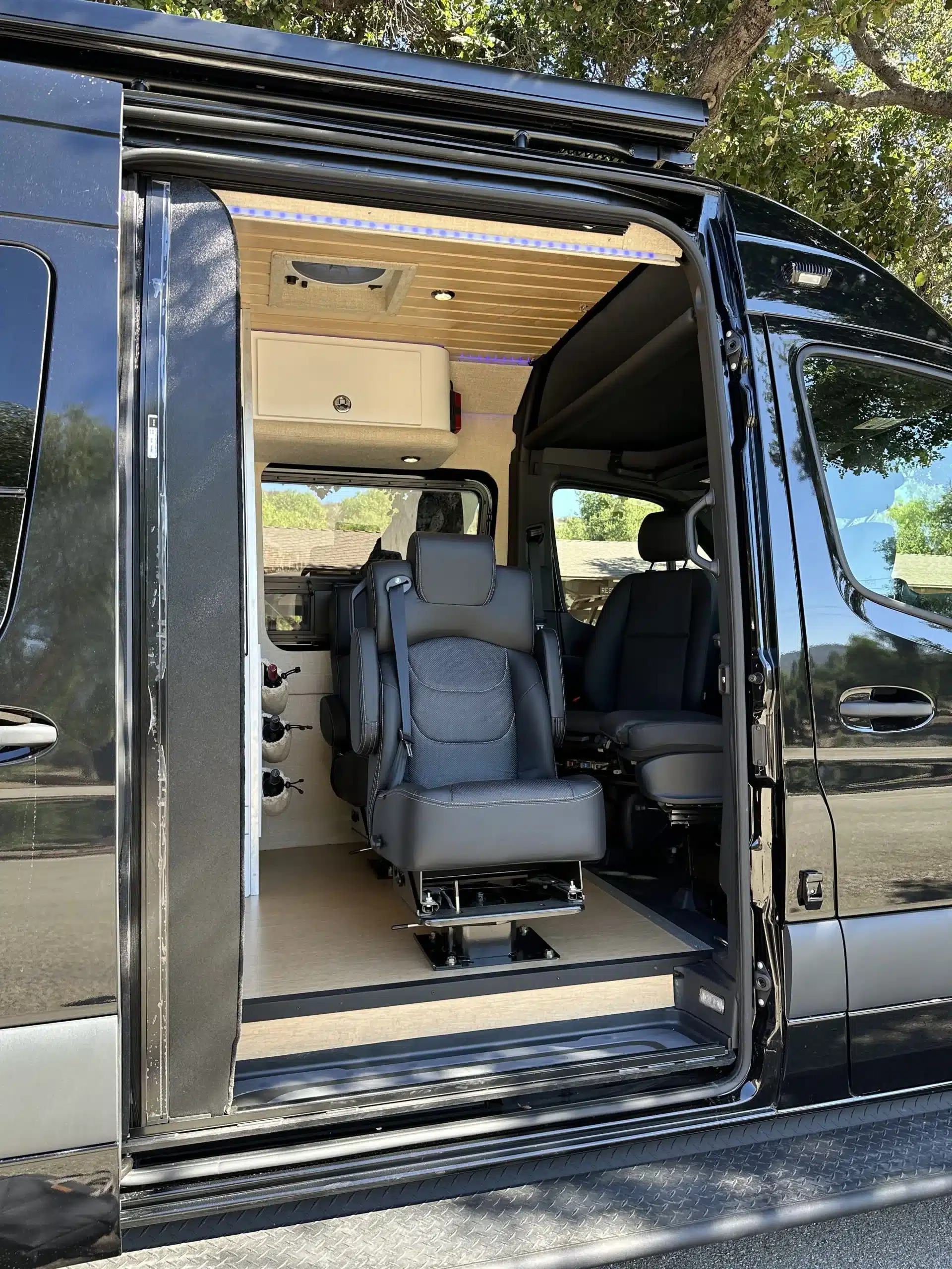 Innenraum des Raven Adventure Van mit geöffneter Schiebetür und Sitzplätzen, ausgebaut auf Basis des Mercedes Sprinter 3500 4x4.