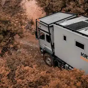 Rhino XL Business Expeditionsfahrzeug von Krug Expedition auf einem Waldweg, umgeben von Pflanzen