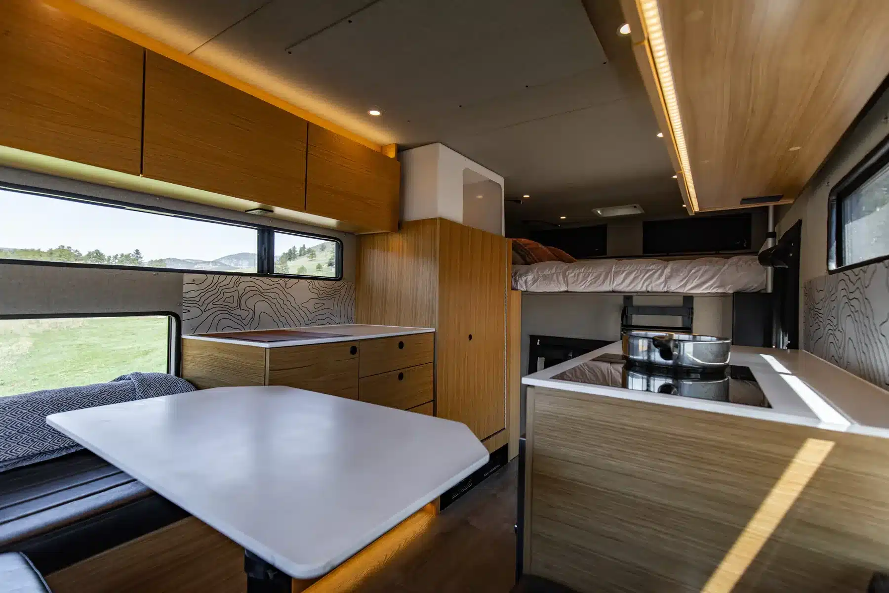 Innenansicht des Rossmönster Baja Plus mit Küche, Essbereich und Bett