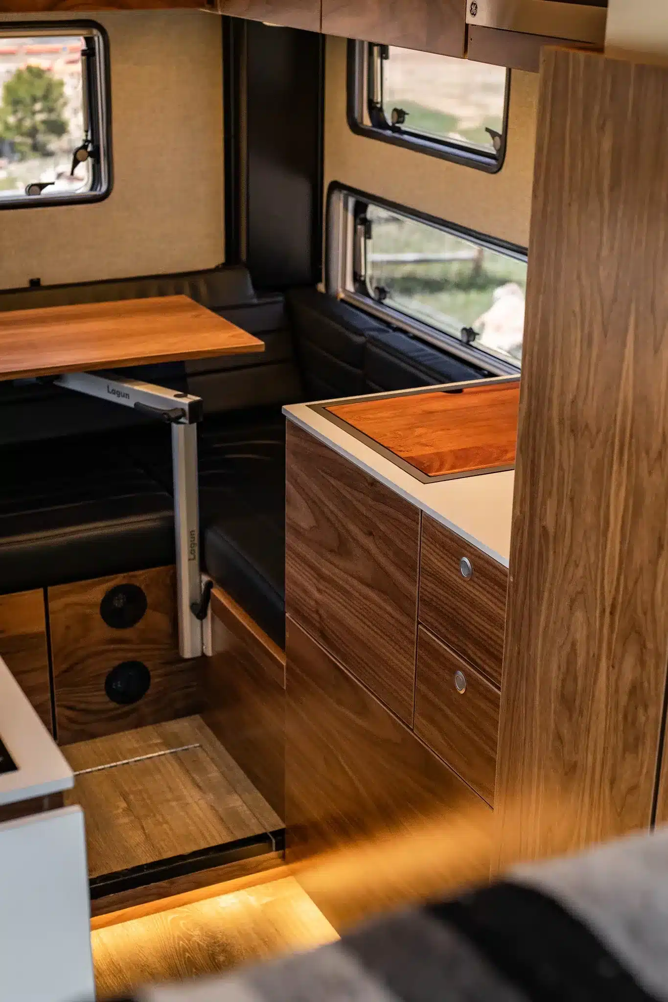 Wohnbereich und Küche des Rossmönster Baja Offroad-Campers mit Holzmöbeln und Dinette