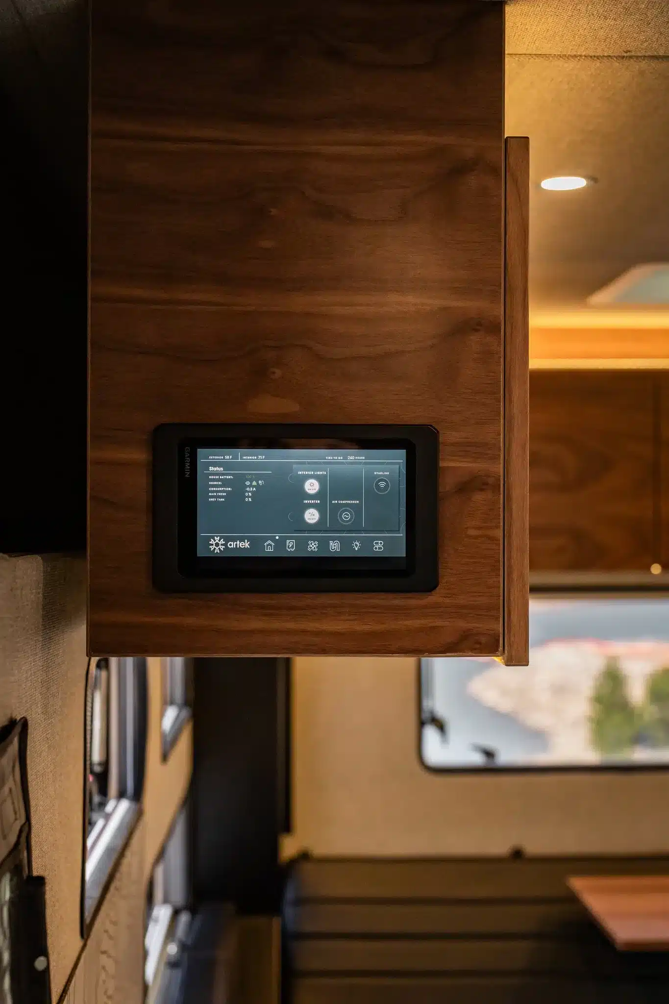 Touchscreen-Bedienpanel im hölzernen Innenraum eines Rossmönster Baja Truckcampers