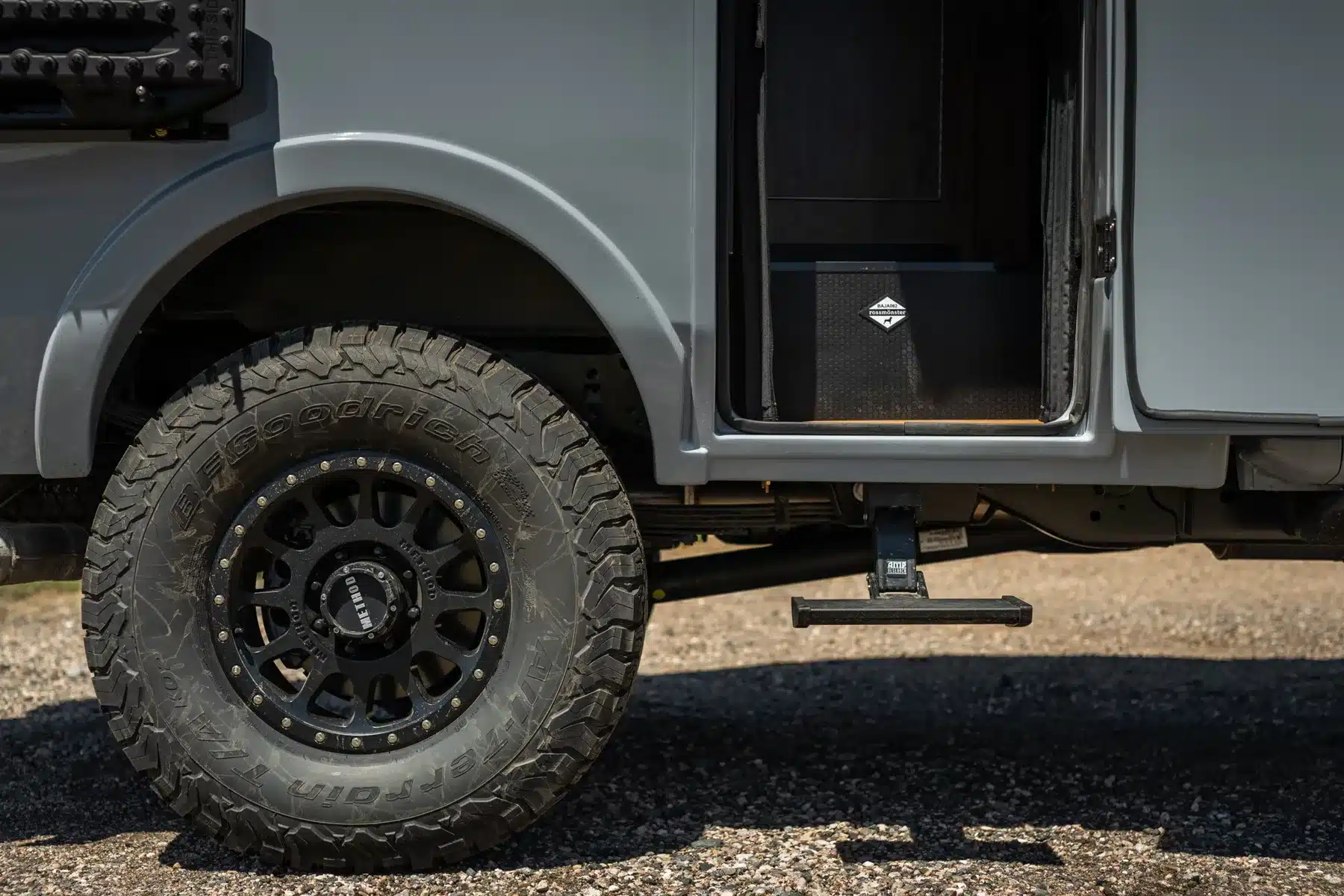 Grobstolliger Offroad-Reifen und aufklappbarer Einstieg an einem Rossmönster Baja Expeditionsfahrzeug