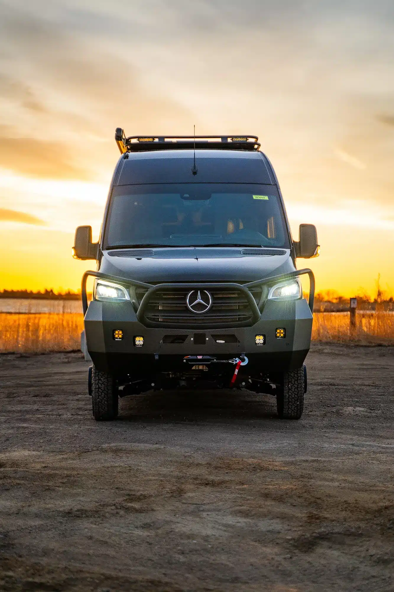 Mercedes Sprinter Rossmonster Edgewood Expeditionsvan mit Dachträger, Zusatzbeleuchtung und Offroad-Stoßfänger bei Sonnenuntergang