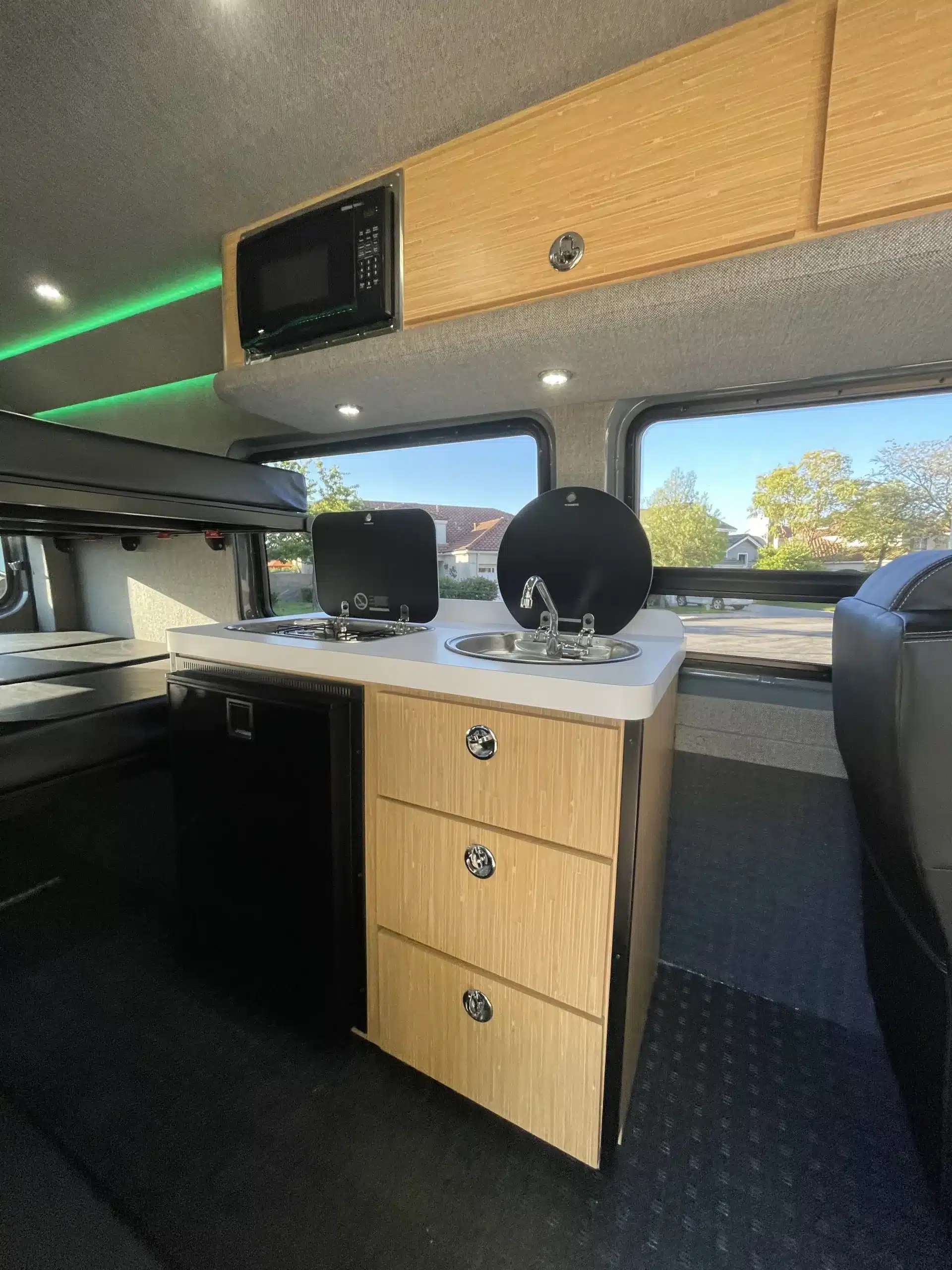Campervan-Innenraum mit Küchenzeile, Spüle, Gaskocher und Mikrowelle im Sprinter 170 4x4