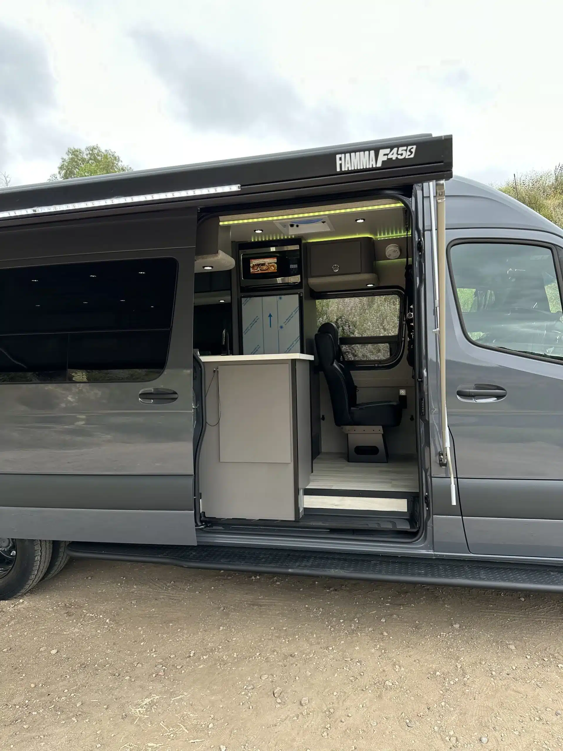 Geöffneter Mercedes Sprinter Campervan Stitch mit sichtbarem Küchenblock und Sitzbereich