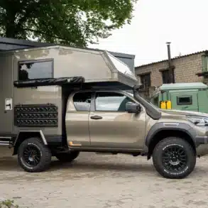 Expeditionsmobil Terrafox auf Pickup-Basis mit robustem Aufbau und Offroad-Ausstattung vor einer Werkstatt.