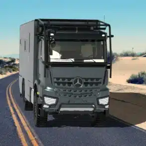 TITAN 60 DQX 4x4 Expeditions-Lkw auf Mercedes Arocs Chassis fährt auf einer Straße durch eine Wüstenlandschaft.