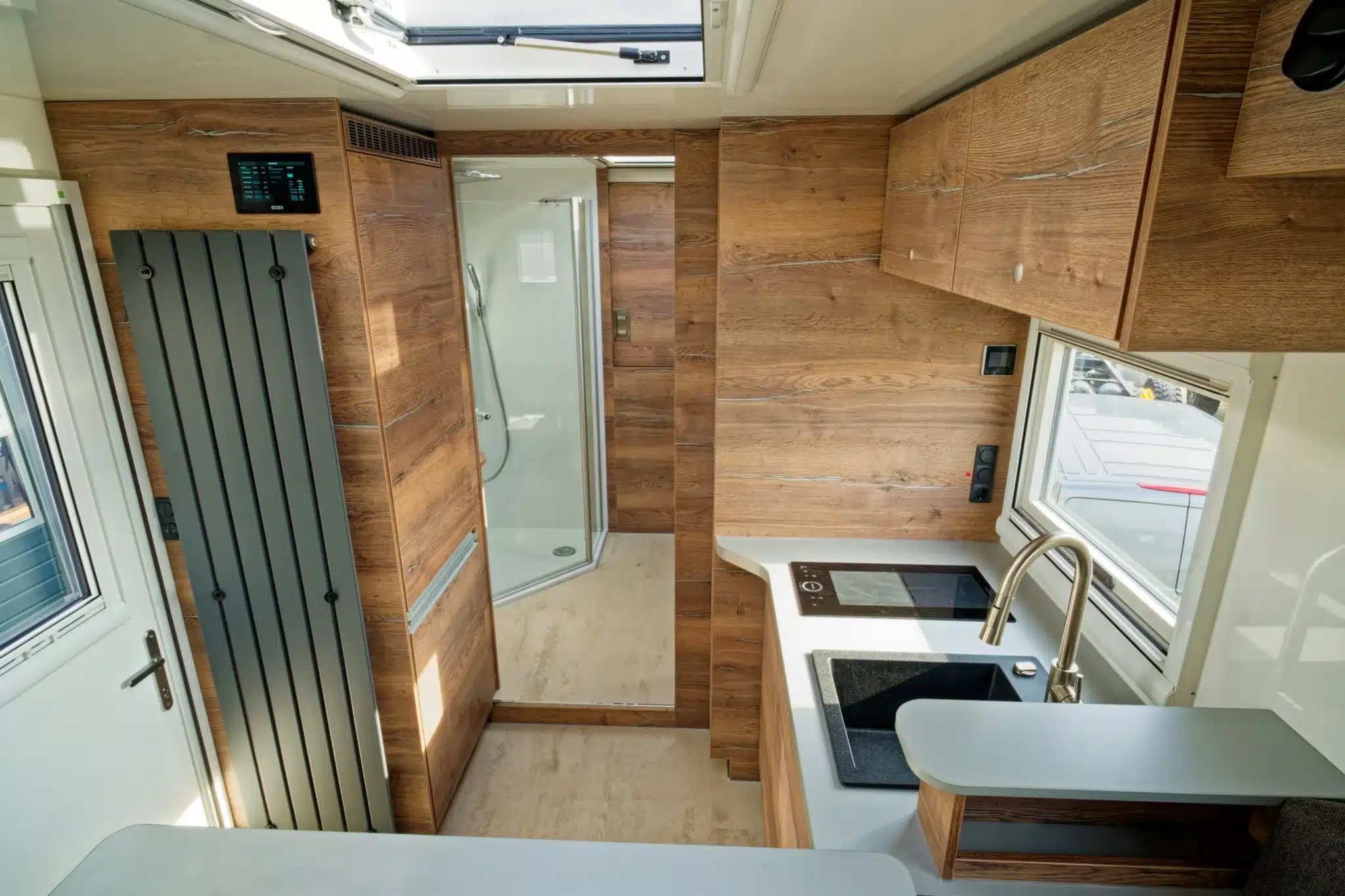 Innenansicht des TITAN 60 UQX 4x4 mit Küche, Spüle, Induktionskochfeld und Bad mit Dusche