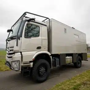 Seitenaufnahme des TITAN 62 UQX 4x4 Expeditionsfahrzeugs auf Mercedes Arocs 2053A Basis auf einer Landstraße.