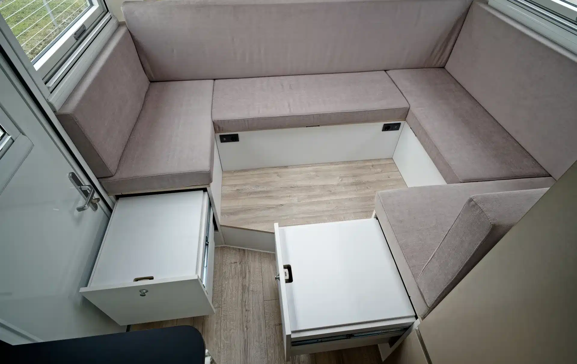 U-Sitzgruppe mit geöffneten Schubladen und abgesteppten Polstern im Innenraum des TITAN 62 UQX 4x4 Expeditionsfahrzeugs.