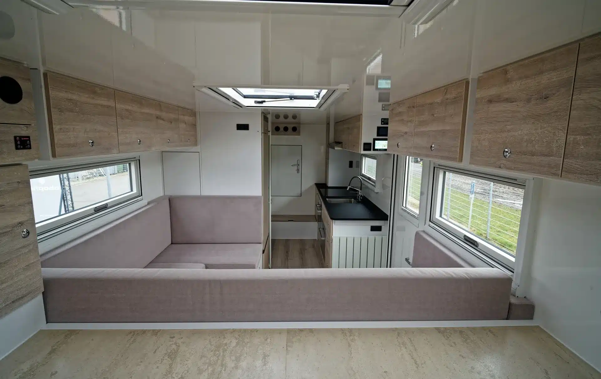 Innenansicht mit U-Sitzgruppe, Küche und Hängeschränken im TITAN 62 UQX 4x4 Expeditionsfahrzeug