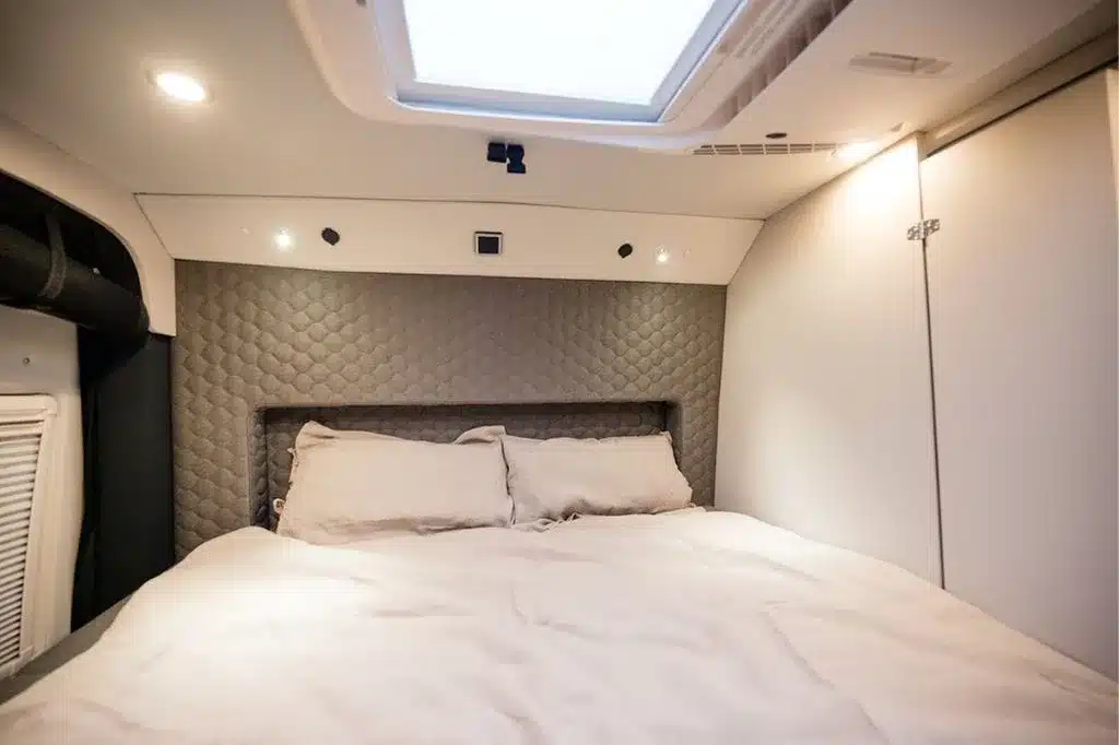 Schlafbereich im Innenraum des Aquila Adventure Creston Crafter 4×4 mit großem Bett und Dachfenster.