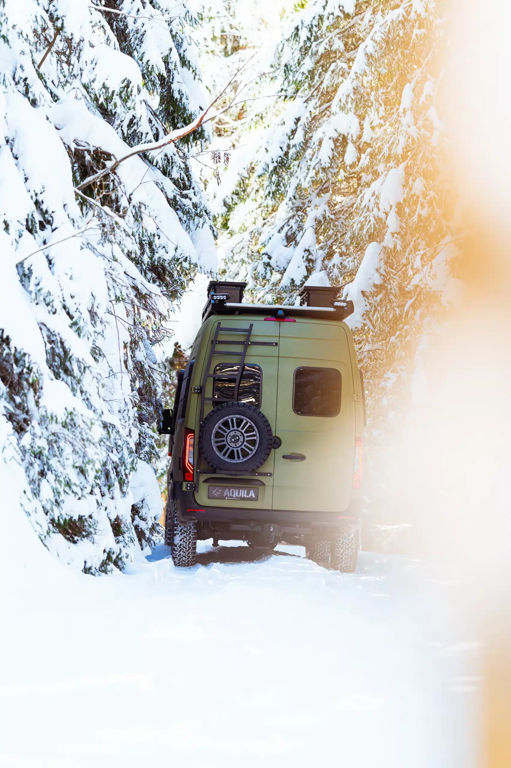 Aquila Adventure Sprinter Stenar 4x4 von hinten auf schneebedeckter Waldpiste