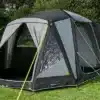 Das Berger Liberta Air freistehende Busvorzelt aufgebaut neben einem Campervan auf einer Wiese.