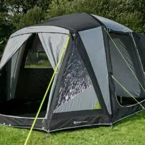 Das Berger Liberta Air freistehende Busvorzelt aufgebaut neben einem Campervan auf einer Wiese.