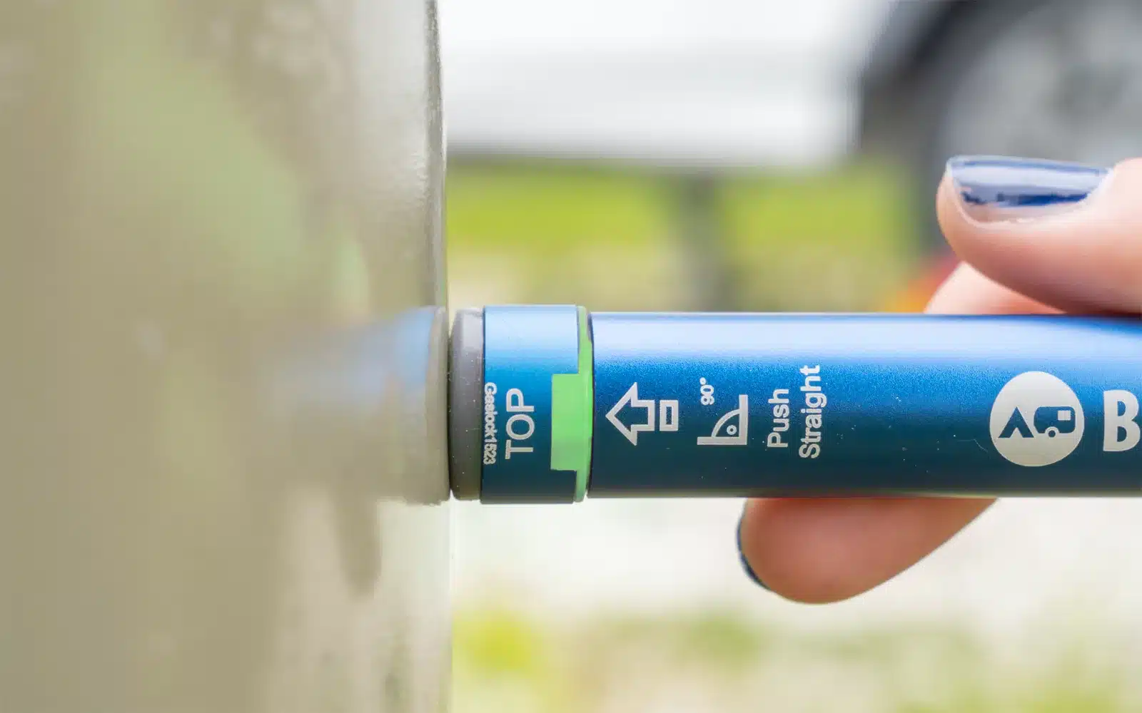 Hand hält den Berger LX10 Gascontrol zum Messen an eine Gasflasche im Camper.