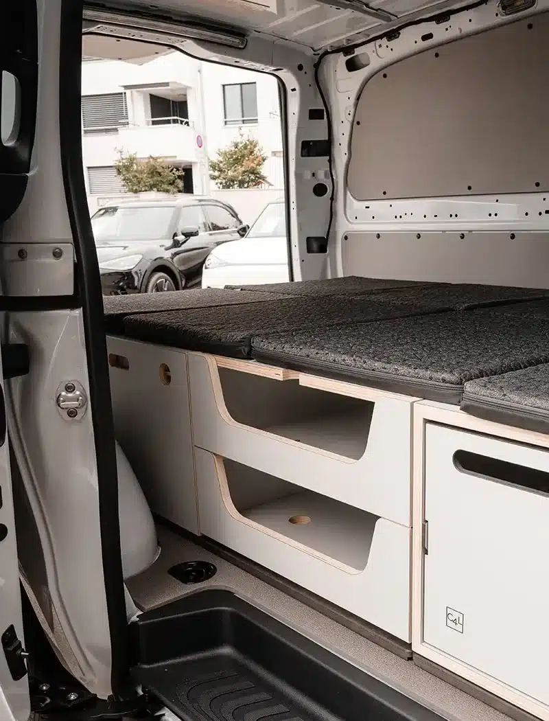 Innenraum eines Transporters mit eingebautem Camper Lite Camping-Modul und Schlafauflage