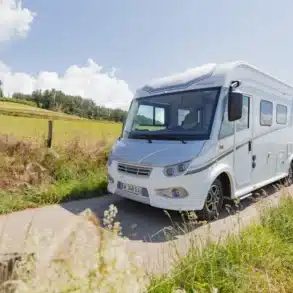 Integriertes Wohnmobil I.Progress Calvia CF fährt auf einer ländlichen Straße bei Sonnenschein