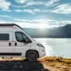 Livingstone Advance K2 Kastenwagen am Ufer eines Sees mit Berglandschaft im Hintergrund.