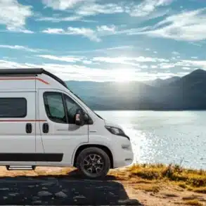 Livingstone Advance K2 Kastenwagen am Ufer eines Sees mit Berglandschaft im Hintergrund.