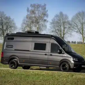 Schwarzer MAN TGE Next Level 6,80 m Van auf Wiese, ideal für den Ausbau als Reisemobil